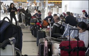 Passengers with their luggage wait for flights at Los Angeles International Airport in Los Angeles. According to a new report, the rate of lost, stolen or delayed bags rose 5 percent in 2013.