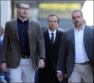Oscar Pistorius, center, accompanied by his relatives, walks towards the high court in Pretoria, South Africa, Tuesday.