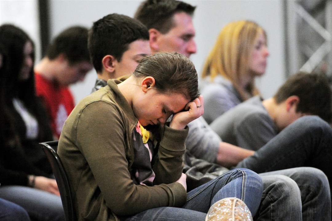 Students-and-their-families-and-friends-pray-during-service