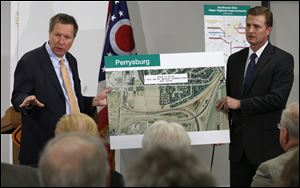 Ohio Governor John R. Kasich, left, and ODOT District 2 deputy director Todd Audet speak during a news conference at the Modern Builders Supply, Inc. in Toledo.