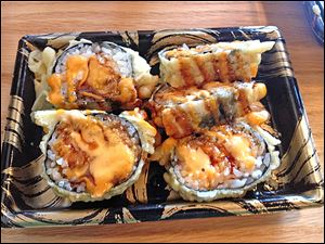 The spicy tempura roll features spicy ground salmon and ground tuna and is coated in a tempura shell.