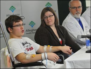 Brett Hurt, left, 16, who was stabbed Wednesday at Franklin Regional Senior High School in Murrysville, Pa., answers a question as his mother, Amanda Leonard, and Dr. Christoph Kaufmann, of Forbes Hospital, listen.