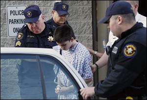 Alex Hribal, center, the suspect in the stabbings at the Franklin Regional High School near Pittsburgh, is taken from a district magistrate after he was arraigned on charges in the attack Wednesday in Export, Pa.
