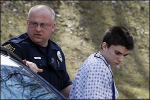 Alex Hribal, the suspect in the multiple stabbings at the Franklin Regional High School in Murrysville, Pa., is escorted by police to a district magistrate to be arraigned Wednesday in Export, Pa.