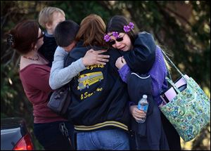 Parents and students embrace along School Road near Franklin Regional High School after more than a dozen students were stabbed Wednesday in Murrysville, Pa.
