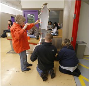 Barbara Miner, professor of art at the University of Toledo, and art majors Carl Krumroy and Shalissa Bailey, install a sketch box.