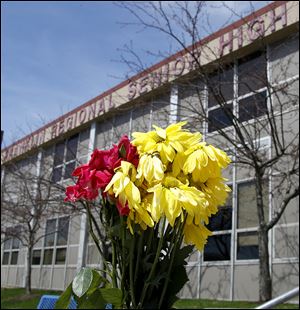 A bouquet of flowers is taped to a stairway rail near the entrance to Franklin Regional Senior High School. Several of the people injured there were expected to undergo additional surgeries.