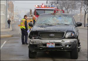 A pickup truck is blocked in by Toledo Police after the driver was halted after striking a pickup with his truck and a business on Monroe Street.