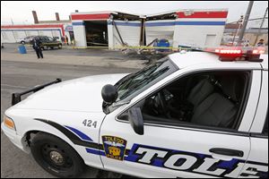 A vehicle crashed Friday into the Carquest Auto Parts at 1717 Monroe St., which was closed at the time. Below, Jonathan Martell talks with Toledo police after his pickup was struck by another vehicle at Monroe and 17th streets.