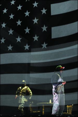 Big Boi, left, and Andre 3000 of hip hop group Outkast perform behind a screen depicting the American flag during their headlining set on the first day of the 2014 Coachella Music and Arts Festival on Friday in Indio, Calif.