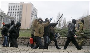 Masked pro-Russian activists march after leaving a regional prosecutor's office today in Donetsk, Ukraine.