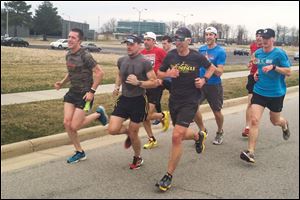 Jon DeWitt, left,  J.P. Miller, and Tim Alderson lead a group of runners at Levis Commons in Perrysburg during a training run Thursday. The three men and Second Sole owner Matt Folk, wearing the red shirt, will be running in the Boston Marathon next week. 