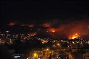 An out of control forest fire rages towards urban areas in the city of Valparaiso, Chile, Saturday.