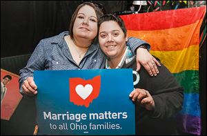 Toledoans  Kristina Quinones, left, and her wife, Jackie Quinones, celebrate Judge Timothy Black's order to recognize same-sex marriages performed in other states. A party was held at Outskirts Pub in Toledo.