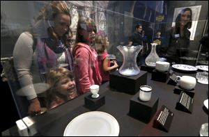 Kristie Miller and her daughter, Madelyn Miller, 12, third from left, and Peighton Hennings, 5, tour the Titanic artifact exhibit at the Imagination Station in Toledo. More than 18,000 people have visited since the exhibit opened in February.