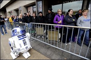 People wait on line next to R2D2 of 