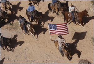 The Bundy family and their supporters fly the American flag as their cattle were released by the Bureau of Land Management back onto public land outside of Bunkerville, Nev.
