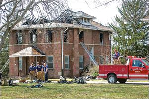 The Tiffin Fire Department conducts exercises on one of the five cottages to be razed at the Tiffin Developmental Center site. Drills on Friday put a hole in the roof and burned the interior.