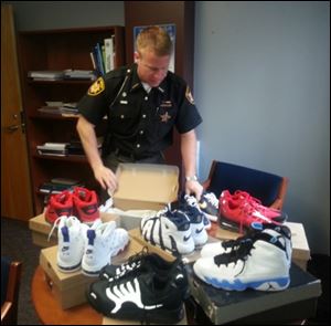 aInspector Bill Holland from the Summit County Sheriff's Department delivered 48 pairs of shoes seized in a drug bust to excited workers at Summit County Children Services in Akron. 
