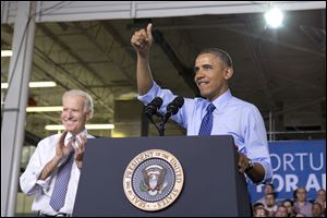 Vice President Joe Biden applauds, at left, as President Barack Obama gives the thumbs up as he talks about his job training program in Oakdale.