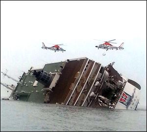 South Korean rescue helicopters fly over a South Korean passenger ship, trying to rescue passengers from the ship in water today off the southern coast in South Korea.