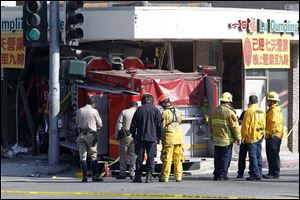 Firefighters and other officials work the scene of an crash where two firetrucks answering a call collided en route to a fire Wednesday in Monterrey Park, Calif. 