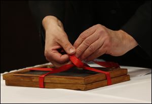 Magician Andrew Martin ties two slates together before his demonstration of mind-reading.
