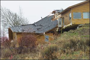 A house breaks apart as a slow-moving landslide in Jackson, Wyo. advances downhill Friday. The slide has cut off access to a 60-person neighborhood.