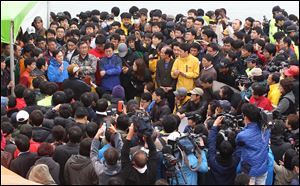 Relatives of missing passengers aboard the sunken ferry Sewol in the water off the southern coast listen to a briefing from a Korea Coast Guard official, left top corner, about a rescue and search operation at a port in Jindo, South Korea, today.