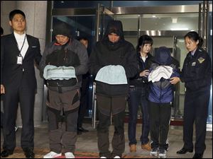 Lee Joon-seok, third from left, the captain of the ferry Sewol that sank off South Korea, and two crew members prepare to leave a court which issued their arrest warrant in Mokpo, south of Seoul, South Korea, today.