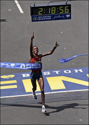 Rita Jeptoo, of Kenya, breaks the tape to win the women's division of the 118th Boston Marathon.