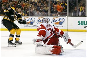 Boston Bruins' Milan Lucic, left, scores on Detroit Red Wings goalie Jimmy Howard during the second period of Game 2 in Boston.