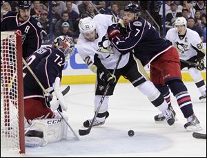 Columbus Blue Jackets' Sergei Bobrovsky (72) makes a save as teammate Jack Johnson, right, tries to clear Pittsburgh Penguins' Lee Stempniak from in front of the net during the first period Monday in Columbus.