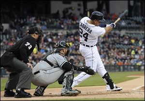 Detroit Tigers' Miguel Cabrera swings on an RBI double off Chicago White Sox starting pitcher Charlie Leesman during the first inning.