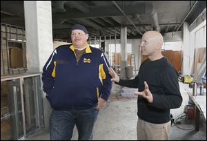 Co-owners Franz Gilis, left, and Nick Kubiak talk about their wine bar that’s being built inside the Commodore Perry Apartments building in Toledo. They hope to be open by the end of spring.