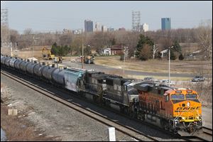 A train transporting ethanol passes through Northwood with the skyline of downtown Toledo in the distance. 