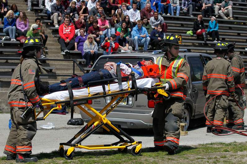 Firefighters-take-away-a-student-acting-injured-during-a-mock-car-accident