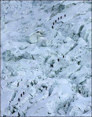 Mountaineers pass through the treacherous Khumbu Icefall on their way to Mount Everest near Everest Base camp, Nepal in May, 2003.