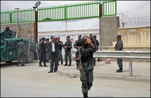 Afghan police forces stand in front of the main gate of Cure Hospital in Kabul, Afghanistan, today.