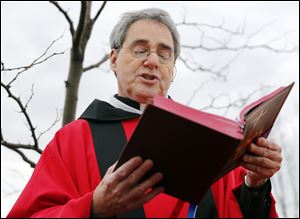 Rev. Herb Weber reads during a Palm Sunday service April 12 at Blessed John XXIII Parish in Perrysburg.