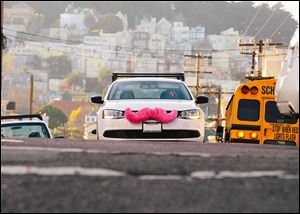 Cars of Lyft, a ride-sharing company that has come to Toledo, sport a pink mustache, the company's trademark.