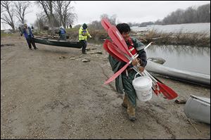 Crew medic Josh ‘Turtle’ Eng carries paddles as the Save Maumee group prepared to launch their boats into the Maumee River at Grand Rapids, Ohio.