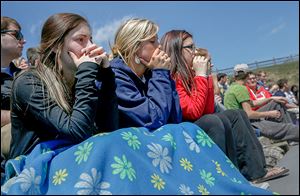 McKenna Keaton, left, Lyndsey Skala, and Kaylee Fryman watch their friends participate in the mock car accident at Rossford High School.