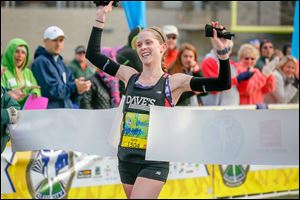 Tamara Marquardt, a Northview graduate who now lives in Shaker Heights, Ohio, crosses the finish line inside the University of Toledo’s Glass Bowl to capture the women’s half marathon.