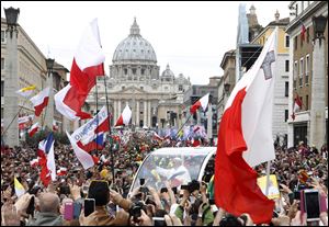 Pope Francis greets faithful as he is driven through the crowd along Via della Conciliazione after celebrating the ceremony for the canonizations of Pope John XXIII and Pope John Paul II today in St. Peter's Square, at the Vatican.