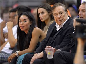 The NBA is investigating a report of an audio recording in which a man purported to be L.A. Clippers owner Donald Sterling, right, makes racist remarks while speaking to V. Stiviano, left.
