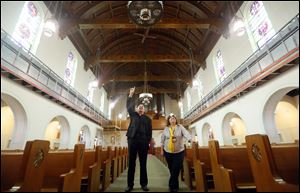 The Rev. Mark Davis, left, and Denise Foos admire the work that is being done to restore the mural inside St. Aloysius Catholic Church.