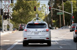 A Google self-driving vehicle navigates a street in Mountain View, Calif. Google’s retrofitted Lexus RX450H sport utility vehicles have a small tower on their roofs that uses lasers to map the surrounding area. Automakers want to hide that technology in a vehicle’s existing shape.