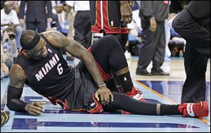 Miami Heat's LeBron James grimaces after being injured during the second half in Game 4.