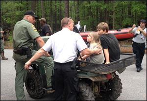 Rescue personnel attend to Dakota Kimbler, 10 and his sister Jade Kimbler, 6, after they were lost with their father inside Congaree National Park.